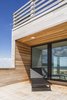 Modern home with Outdoor, Rooftop, Decking Patio, Porch, Deck, Wood Patio, Porch, Deck, Horizontal Fences, Wall, and Wood Fences, Wall. Riverside deck looking through house to ocean Photo 15 of Sea Bright House