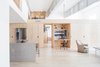 Modern home with Living Room, Chair, Coffee Tables, Recessed Lighting, Track Lighting, and Light Hardwood Floor. Living space looking toward central organizing "spine" built entirely of plywood Photo of Wells Fargo Loft