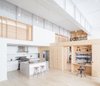 Modern home with Kitchen, Concrete Counter, Subway Tile Backsplashe, White Cabinet, Light Hardwood Floor, Track Lighting, Accent Lighting, Recessed Lighting, Range, Refrigerator, and Range Hood. Living and kitchen space with loft bedrooms above Photo 3 of Wells Fargo Loft