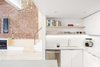 Modern home with Kitchen, White Cabinet, Concrete Counter, Light Hardwood Floor, Subway Tile Backsplashe, Recessed Lighting, Track Lighting, Dishwasher, Accent Lighting, and Undermount Sink. Kitchen looking toward plywood stair and bench seat Photo 5 of Wells Fargo Loft