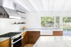 Modern home with Kitchen, Range, Range Hood, Dishwasher, Marble Counter, Wood Cabinet, Medium Hardwood Floor, Ceramic Tile Backsplashe, Track Lighting, Ceiling Lighting, and Undermount Sink. Kitchen looking to back yard Photo 6 of Deertrack Lane