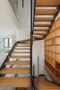 Modern home with Staircase, Metal Tread, Glass Railing, and Wood Tread. The sweeping staircase in CK House by Christiana Karagiorgi Architects runs alongside the home's wooden library. Photo 13 of CK House
