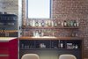 Modern home with Kitchen, Beverage Center, Ceramic Tile Backsplashe, Wood Counter, Colorful Cabinet, and Light Hardwood Floor. An open bar area was designed just off the kitchen for easy entertaining. Custom walnut shelving floats against the brick wall and pairs with modern black cabinetry below. Working with the 100 year old brickwork brought its own challenges. "The brickwork is beautiful but nothing was level, the brick undulates in and out and adds to the difficulty when you want a clean modern finish. Our fantastic team of builders took this challenge to heart and came up with solutions to address the uneven walls throughout the space," Murdock adds. Photo 4 of Details Make the Difference in this San Francisco Urban Loft