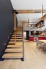 Modern home with Staircase, Wood Tread, Metal Railing, and Cable Railing. Murdock also redesigned the loft's stairwell with open risers, however there were design challenges to overcome here as well. "Due to the varied nature of the reclaimed material, there were several large cracks that we needed to address both aesthetically and structurally. The team came up with beautiful solutions to minimize the appearance of imperfections and address all the stability issues," says Murdock. Photo 7 of Details Make the Difference in this San Francisco Urban Loft