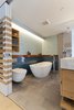 Modern home with Recessed Lighting. The original bathroom was poorly planned and when Murdock opened up its walls she discovered unused space that could be reclaimed. As a result, the upper bathroom that once housed only a small stand up shower and vanity now includes a free standing bath, open shower and double vanity. Ceramic tiles in beautiful ocean and sky blues bring soothing colors to the space where Murdock added a custom teak border and shelving above the tub. Integrated shelving and custom cubbies were also added for much needed storage. A wall hung toilet opens up the space even further. Photo 11 of Details Make the Difference in this San Francisco Urban Loft
