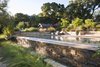 From the bocce court level, the infinity edge of the pool acts as a feature, with water spilling down the stone face.
The small barn was reclaimed from the existing agrarian buildings on the property, and now houses the pool mechanical.
By Arterra Landscape Architects. Photo by Michele Lee Willson Photo of Homestead on Whiskey Hill modern home