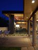 The existing patio porch framing was saved and covered with birch panel plywood to unite the interior and exterior. The framing is supported by steel wide-flange beams and concrete columns echoing the interior language. Photo 4 of The Silvertree Residence modern home