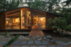 Modern home with Exterior, Wood Siding Material, House Building Type, Shingles Roof Material, Glass Siding Material, Gable RoofLine, Cabin Building Type, Mid-Century Building Type, and Metal Roof Material. The exterior terrace, water channel, deck, and window wall of Matt and Jon Andersen-Miller's renovated midcentury home. Photo of Architect's own Home