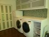 The 30" deep counter over the washer and dryer provides a convenient folding area, and the slide-out baskets are used as hampers. The refrigerator was installed primarily for storage of dog food, but also provides valuable over-flow space for the kitchen refrigerator, particularly when we are entertaining. The large closet provides plenty storage for cleaning supplies, and also features hanging space for laundry. Photo 6 of Modern Laundry, Pantry and Dog Room modern home