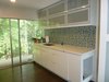 The high gloss white cabinets are by Ikea. The tall cabinet to the left of the dog feeding area features slide-out dog food storage. The countertops are Formica brand Acrylic solid surface. Photo 3 of Modern Laundry, Pantry and Dog Room modern home