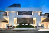 Modern home with Outdoor, Trees, Grass, Shrubs, Garden, Raised Planters, Front Yard, Stone Patio, Porch, Deck, Concrete Patio, Porch, Deck, Metal Patio, Porch, Deck, Horizontal Fences, Wall, Metal Fences, Wall, and Landscape Lighting. Street view, frontal, dusk Photo 10 of A House in Yarmouk