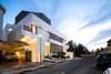 Modern home with Outdoor, Trees, Shrubs, Grass, Raised Planters, Gardens, Garden, Concrete Patio, Porch, Deck, Front Yard, Stone Patio, Porch, Deck, Horizontal Fences, Wall, Metal Patio, Porch, Deck, Metal Fences, Wall, and Landscape Lighting. Street view, dusk Photo 11 of A House in Yarmouk