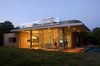 Modern home with Exterior, House Building Type, Wood Siding Material, Glass Siding Material, Flat RoofLine, and Prefab Building Type. Night Shot with corner window open Photo of Sandbox