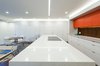 Modern home with Kitchen, Engineered Quartz Counter, Cooktops, Refrigerator, White Cabinet, Wood Backsplashe, Recessed Lighting, Medium Hardwood Floor, Accent Lighting, and Colorful Cabinet. View of Kitchen Area Photo 2 of DC Waterfront Residence
