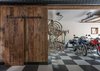 Modern home with Garage and Storage. This garage space uses iconic checkerboard floor tiles to contrast the rustic barn door that provides entry to the rest of The Barn. Photo 5 of The Barn