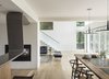Modern home with Living Room, Chair, Recessed Lighting, Sofa, Pendant Lighting, Bench, Two-Sided Fireplace, and Light Hardwood Floor. View from open kitchen /dining area toward living room and stairs Photo 5 of The River House