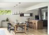 Modern home with Kitchen, Engineered Quartz Counter, Wood Cabinet, Pendant Lighting, Range, Recessed Lighting, Refrigerator, Light Hardwood Floor, Range Hood, and Drop In Sink. View of dining and kitchen area Photo 8 of The River House