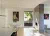 Modern home with Living Room, Sectional, Recessed Lighting, Two-Sided Fireplace, and Light Hardwood Floor. The kitchen opens to dining and family room area, separated by see through gas fireplace. Photo 10 of Old Greenwich House
