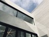 Modern home with Exterior, Wood Siding Material, Metal Roof Material, Stucco Siding Material, House Building Type, and Flat RoofLine. Grey stucco and stained wood siding grace the exterior elements of the home along with custom black framed windows and bi-fold doors. Photo 5 of Wylan/James Residence