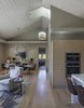The volume of the great room with its tall ceilings and doors makes the relatively small space feel grand. A neutral palette, light oak floors and cabinets and dramatic lighting add to the drama. Photo 4 of A New Beginning modern home