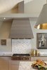 Stove hood is an iconic shape, done in horizontal grain oak stained dark. Marble mosaic tile over a Wolf range top. Photo 10 of A New Beginning modern home