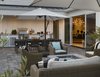 The outdoor space is furnished with comfortable lounge chairs, a large dining table and moveable umbrellas for shade. Photo 12 of A New Beginning modern home