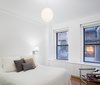 Built in radiator millwork and minimized window detailing helped brighten up the bedroom. Photo 7 of Prewar Modern Upgrade modern home
