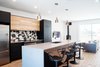 Kitchen is open to the living room, JOTUL fireplace, RAMACIERI SOLIGO tiles, CEASAR STONE quartz countertops, RIOBEL faucets and stools are by MAISON CORBEIL Photo 6 of Concept DUB House modern home