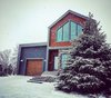 A rustic/modern exterior to blend with the neighborhood. Stone by CULTURED STONE, Pine wood by BOIS ADIRONDACK, custom made front door by FENETRES 2000 and custom made fixtures by LUMINAIRE AUTHENTIK Photo 10 of Concept DUB House modern home