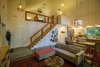 An open staircase at the center of the house rises to a multi-purpose loft. Along with a storage room tucked under the stairs, the owners use the wall there to display a collection of mirrors. Photo 14 of Modern, Passive, Net Zero Farmhouse modern home