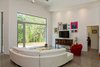 Modern home with Living Room, Concrete Floor, Recessed Lighting, and Sectional. A wall of aluminum-framed glazing provides a full view of the forest beyond the homeowners' property, Photo 13 of The Serdar Net Zero-Net Positive Micropolis® House