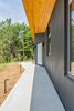 Modern home with Exterior, Shed RoofLine, Concrete Siding Material, Metal Roof Material, and House Building Type. A simple cement walkway leads from the garage to the front door and mirrors the angle of the entrance. Photo 5 of The Serdar Net Zero-Net Positive Micropolis® House