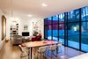 Modern home with Dining Room, Recessed Lighting, Table, Medium Hardwood Floor, Chair, and Ribbon Fireplace. View from the new kitchen to the fireplace that anchors the space at the opposite end. The glass wall provides views of the backyard and the architecturally diverse neighborhood. Photo 11 of Hillcrest House Addition: An Innovative Approach to Old + New