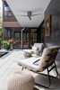 Modern home with Exterior, House Building Type, Wood Siding Material, Metal Roof Material, Metal Siding Material, and Flat RoofLine. The patio's back wall is clad in steel. The screened porches can be seen beyond the patio. Photo 6 of The Thomas Residence