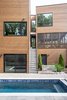 Modern home with Outdoor, Back Yard, Landscape Lighting, Hardscapes, Grass, Trees, Walkways, Swimming Pools, Tubs, Shower, Pavers Patio, Porch, Deck, and Wood Fences, Wall. An outdoor staircase leads from the main living level down to the pool, past the daylight basement. Photo 8 of The Thomas Residence
