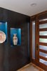 Modern home with Hallway and Light Hardwood Floor. The steel wall outside the main entrance continues into the foyer. Photo 9 of The Thomas Residence