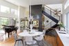 Modern home with Light Hardwood Floor and Pendant Lighting. Beyond the dining space, an open staircase provides vertical circulation. Photo 12 of The Thomas Residence