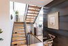 The black steel and white oak on the staircase echo the white oak flooring and steel wall nearby. Photo 13 of The Thomas Residence modern home