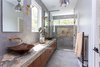Modern home with Engineered Quartz Counter. The master bath features Shadow Onyx for the vanity countertop, the shower bench, and the shower back panel. The floor tile, vanity wall and shower are Resing Berlin Grey tile. The twin sinks are custom copper. Photo 14 of The Thomas Residence