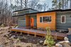 Modern home with Exterior, House Building Type, Flat RoofLine, and Metal Roof Material. On the east (entry) elevation facing the approaching road, strong horizontal lines in the fiber cement cladding and a cypress accent wall contribute to the house’s relaxed ease in its setting. A ramp provides a zero-threshold, age-in-place entry to the front door. Photo of The Mason-Grabell "Beech" House