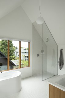 The third-floor master bathroom at Slender House enjoys a vaulted ceiling that helps create a sense of volume and spaciousness—even while showering.