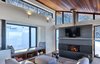 Modern home with Living Room, Medium Hardwood Floor, Sofa, Wall Lighting, Accent Lighting, Wood Burning Fireplace, Sectional, Light Hardwood Floor, Ottomans, Bench, and Two-Sided Fireplace. Stuv fireplace and window seat with an up mountain view. Photo 6 of Laurentian Ski Chalet