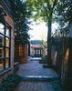 A view from the Lombard Street entry garden. A new terraced series of patios creates generous outdoor rooms for the owner who entertains frequently. The new kitchen addition, expanded dining room bay, and sensitive material selections; making use of herringbone brick pavers, Pennsylvania bluestone pavers, and dark painted wood framed windows and doors work to complement the historic 1860's townhome and blur the lines of what is new and what is original to the property. By RobitailleCurtis Photo of Fitler Square House & Garden modern home