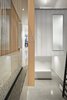 Modern home with Living Room, Shelves, Concrete Floor, Bookcase, Recessed Lighting, Accent Lighting, Storage, and Ceiling Lighting. A detail view of the douglas fir wood slats and the glass guardrail as they meet the concrete bridge that spans the atrium at the second floor level. Photo 9 of Atrium Townhome