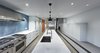 Modern home with Kitchen, White Cabinet, Concrete Floor, Ceramic Tile Backsplashe, Pendant Lighting, Recessed Lighting, Range Hood, Range, Undermount Sink, and Marble Counter. Alvar Aalto's A330 pendant fixtures above the kitchen island. Photo 7 of Atrium Townhome