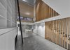 Modern home with Living Room, Pendant Lighting, Shelves, Accent Lighting, Recessed Lighting, Standard Layout Fireplace, Ceiling Lighting, Concrete Floor, Storage, Bookcase, and Gas Burning Fireplace. Cascade coil drape keeps the owner's great dane out of the kitchen. Photo 5 of Atrium Townhome