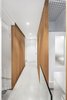 Modern home with Hallway and Concrete Floor. Concrete bridge at second floor leading to master bedroom. Glass guardrail at opening to atrium with Douglas Fir wood slats on each side. Photo 17 of Atrium Townhome