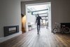Modern home with Living Room, Table, Ceiling Lighting, Lamps, Wood Burning Fireplace, Gas Burning Fireplace, and Dark Hardwood Floor. A large glass roof and removal of many internal walls, opens the old Victorian house to a flood of daylight. Photo of THE GLASSHOUSE