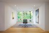 Situated on a sloped-site, each renovated space provides a unique perspective and vista to the dramatic natural surroundings. The office, with its stark modern furnishings and subtle artwork, allows the large window to serve as perhaps the most dramatic, singular frame to the foliage beyond. Photo 9 of Modern Victorian modern home