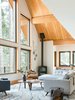 Modern home with Living Room, Sectional, Corner Fireplace, Chair, Rug Floor, Light Hardwood Floor, and Wood Burning Fireplace. Regan Baker Design teamed up with contractor Markus Burkhardt and Sagan Design Group to design and build Tahoe’s first Passive House for a family of five, incorporating their vintage and heirloom quilts. Photo 2 of Woodsy Tahoe Cabin